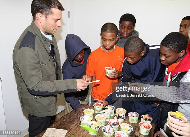Michael Sloan of The Soft Serve Fruit poses with youth from Urban Promise during Celebrities For Smiles hosted by Kris Humphries at Smile Design...