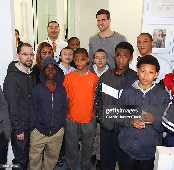 Kris Humphries poses with Alexandre Gause DDS, Lee Gause DDS of Smile Design Manhattan and 12 youth from Urban Promise during Celebrities For Smiles...