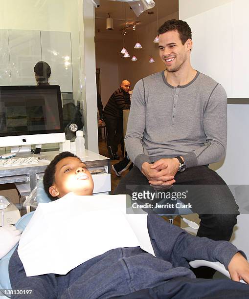 Kris Humphries looks on as Tariq of Urban Promise receives dental care during Celebrities For Smiles hosted by Kris Humphries at Smile Design...
