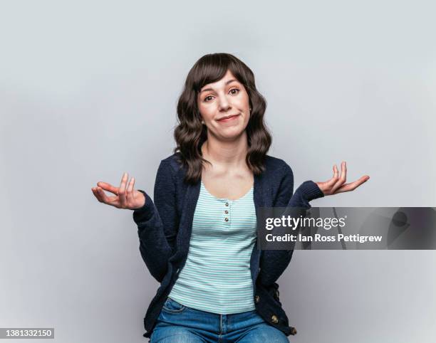 cute latina gesturing "i don't know" - shrug shoulders stockfoto's en -beelden