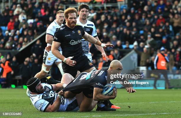 Olly Woodburn of Exeter Chiefs dives over for the first try despite being held by Bevan Rodd during the Gallagher Premiership Rugby match between...