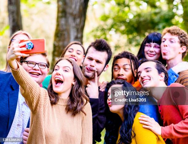 huge mixed race and gender group of young  friends, gen z university students, use a cell phone to make a video or take a selfie for fun content creation or social media - 青少年組織 個照片及圖片檔