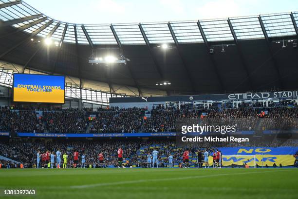 Players, officials and fans take part in a minutes applause to indicate peace and sympathy with Ukraine ahead of the Premier League match between...