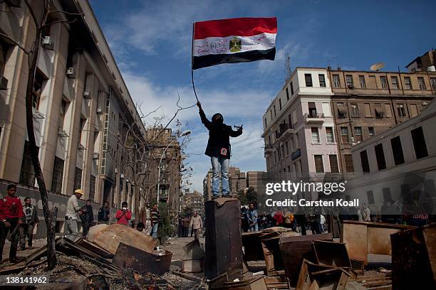 Protester waves an Egyptian flag on the top of a barrier during clashes between protesters and riot police near the interior ministry February 3,...