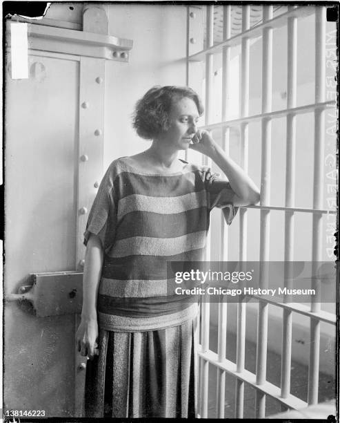 Mrs. Belva Gaertner standing and looking through jail cell bars, Chicago, Illinois, March 13, 1924.