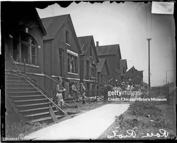 Chicago race riot, soldiers with rifles standing guard at vandalized house, Chicago, Illinois, July 30, 1919.