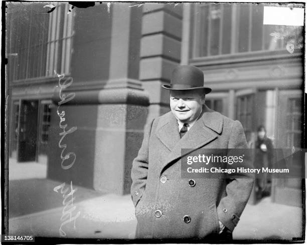 Roscoe Arbuckle, movie actor, standing with his hands in coat pockets on sidewalk, Chicago, Illinois, 1920.