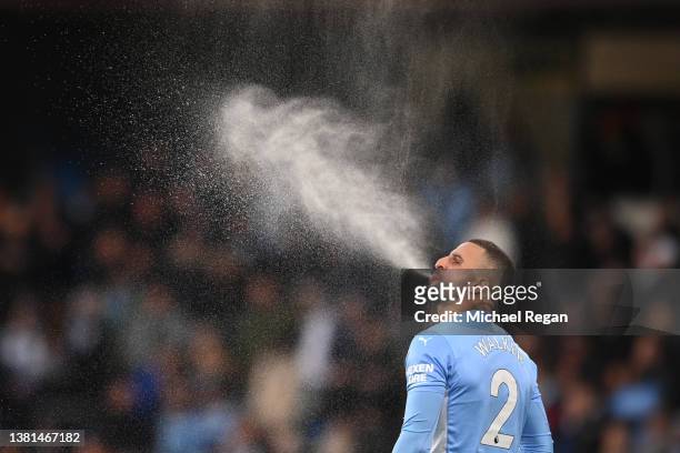 Kyle Walker of Manchester City sprays water during the Premier League match between Manchester City and Manchester United at Etihad Stadium on March...