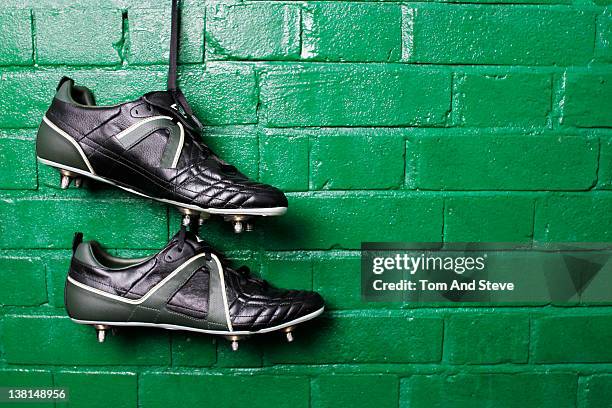 football boots hanging in changing room wall. - locker room wall stock pictures, royalty-free photos & images