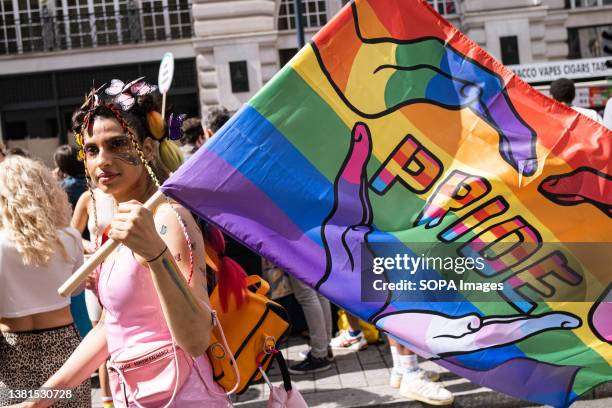Spectator is seen holding a rainbow flag during the Pride parade. Pride Parade, as one of the highlights of Pride Month, takes place in Central...