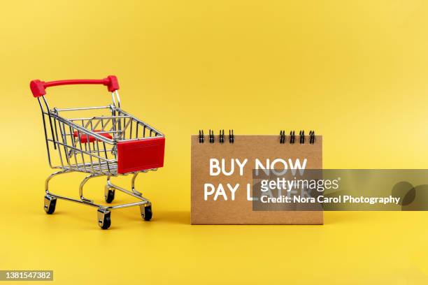 buy now pay later sign on yellow background - tijdslimiet stockfoto's en -beelden