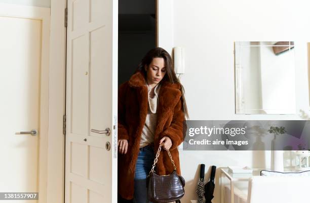 beautiful long-haired woman arriving home after work, dressed in cold weather coat and fashionable clothes. - woman arrive home stock pictures, royalty-free photos & images