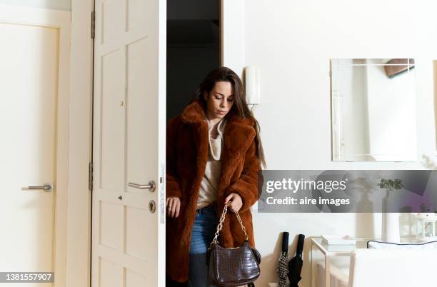 beautiful long-haired woman arriving home after work, dressed in cold weather coat and fashionable clothes. - opening front door stock pictures, royalty-free photos & images