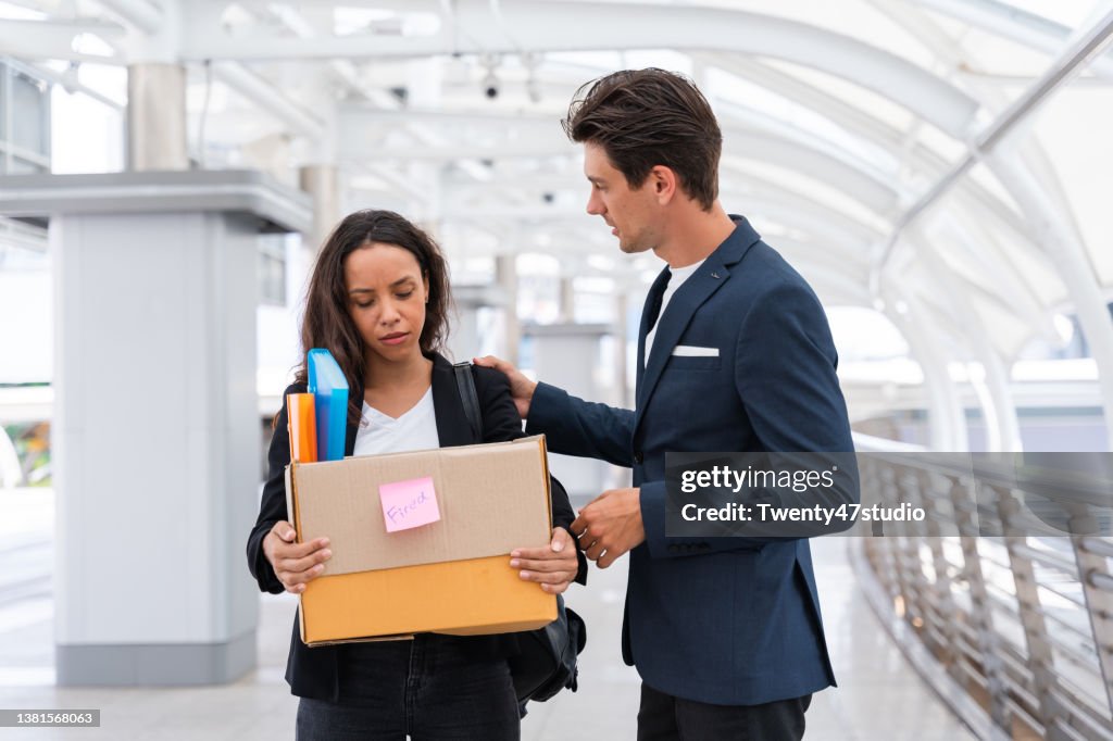 Man consoling his working colleagues being fired lost the job