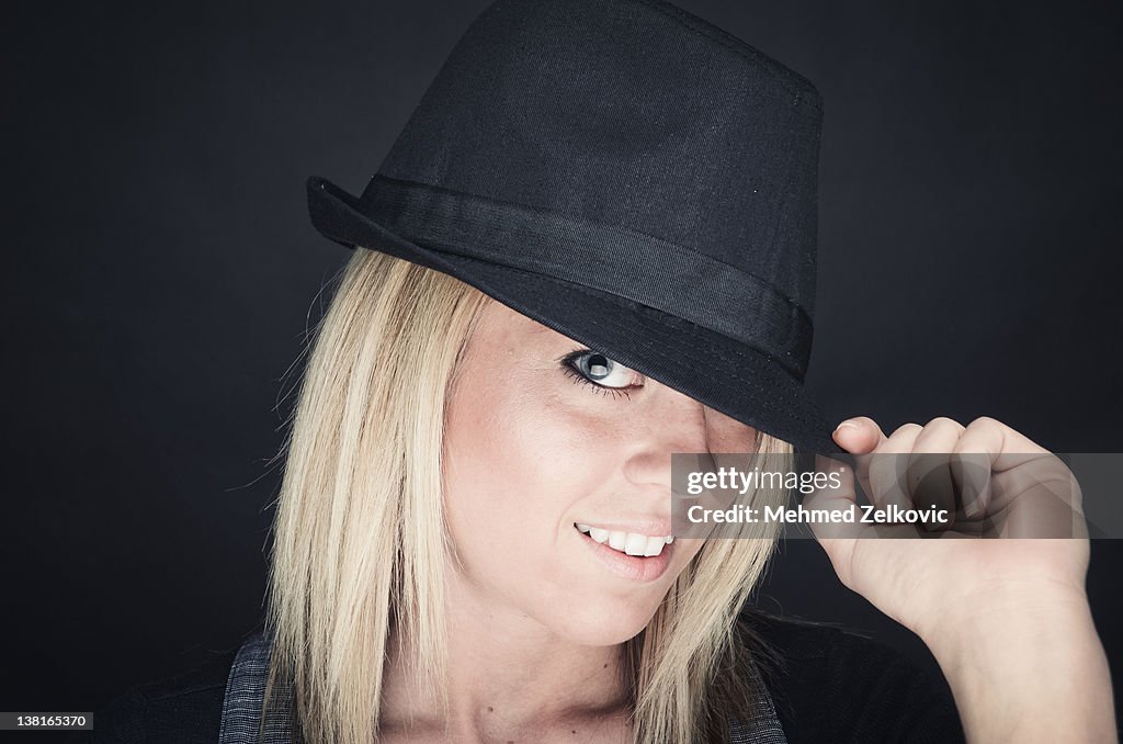 Portrait of young woman with tilted hat