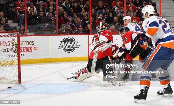 February 3: Mark Eaton of the New York Islanders watches his game winning over-time goal get past Craig Anderson of the Ottawa Senators during an NHL...