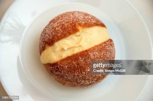 maritozzo / maritozzi - a vanilla cream filled roman sweet bun - on a white plate at an outdoor cafe - custard fotografías e imágenes de stock