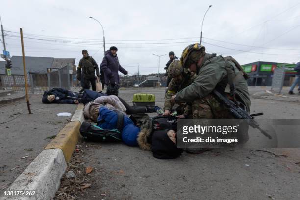 Ukrainian soldiers try to aid the victims of a mortar attack from Russian forces on March 6, 2022 in Irpin, Ukraine. At least four died in the...