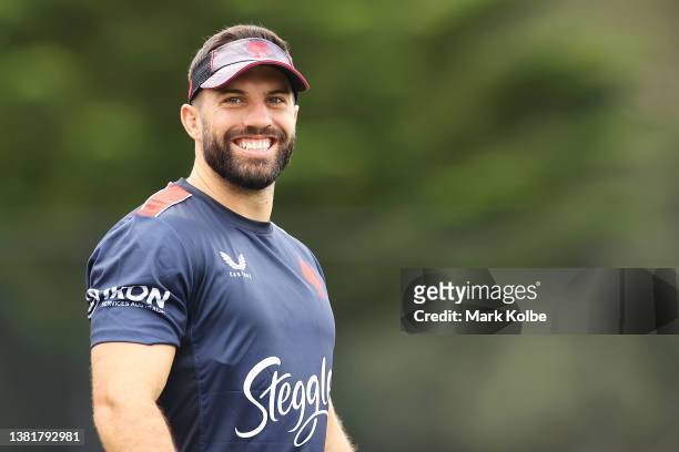 James Tedesco shares a laugh with a team mate during a Sydney Roosters NRL training session at Robertson Road Synthetic Field on March 07, 2022 in...