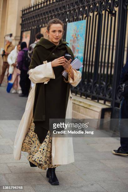 Guest wears a Celine by Phoebe Philo deconstructed green jacket/white dress trench, yellow floral dress, and black boots at the Valentino Show at...