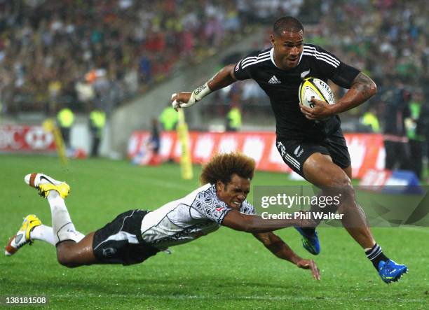 Frank Halai of New Zealand breaks through the tackle of Osea Kolinisau of Fiji to score a try during the Cup Final on day two of the Wellington...