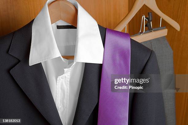 anzug und krawatte in einem schrank - black suit purple shirt stock-fotos und bilder