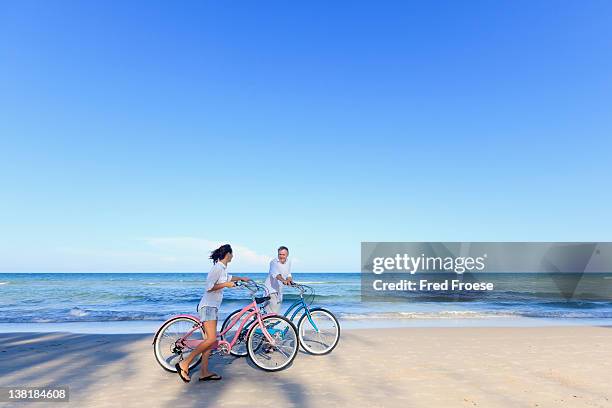 mature couple with bikes on beach - hua hin thailand stockfoto's en -beelden