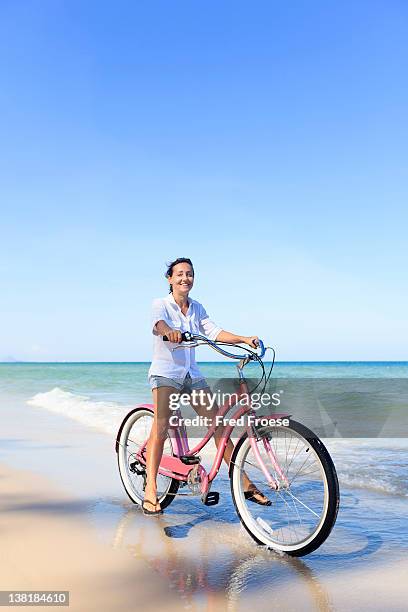 mature woman posing with bike on beach - hua hin stock pictures, royalty-free photos & images