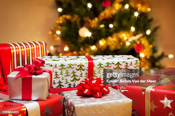 group of christmas gifts in front of tree. - クリスマスプレゼント ストックフォトと画像