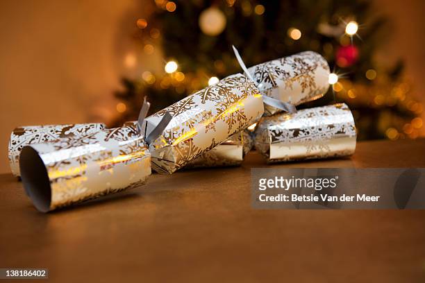 christmas crackers laying on table. - christmas cracker stock pictures, royalty-free photos & images