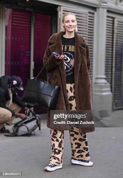 Model Aubrey Hill is seen wearing a faux fur brown coat, vintage t-shirt, animal print pants and a black bag outside the Valentino show during Paris...