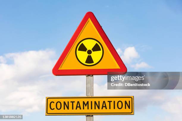 danger traffic sign with the nuclear symbol and sign that says: 'contamination', with the sky in the background. concept of war, ukraine, russia and war conflict. concept of energy and chemical weapon,. - segnale di pericolo di radiazioni foto e immagini stock