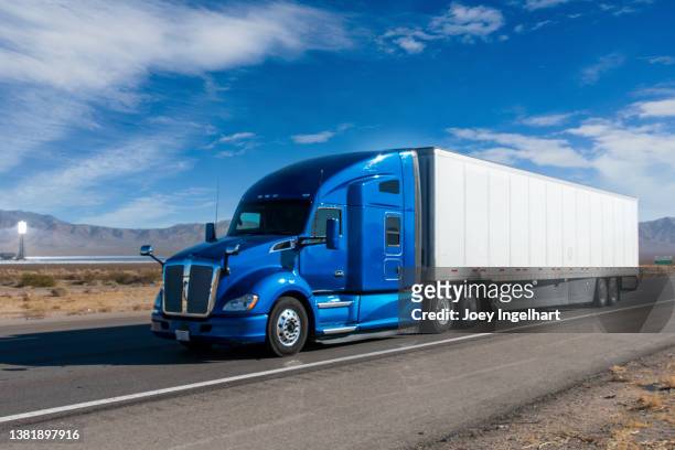 semi trucks on a four lane highway near the ivanpah solar power facility - semi truck stock pictures, royalty-free photos & images