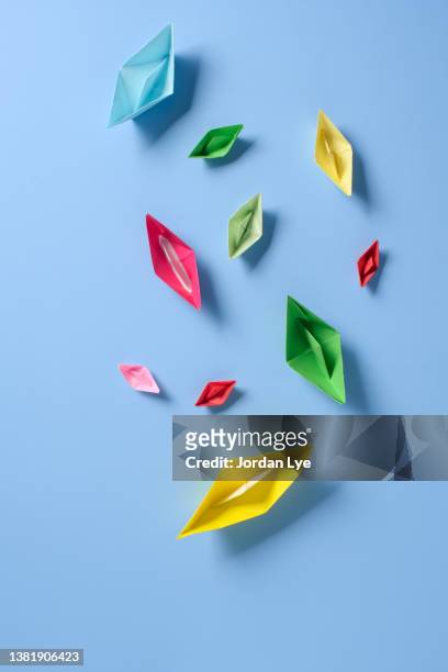 colorful origami paper boats with baby blue background. - origami boat stock pictures, royalty-free photos & images