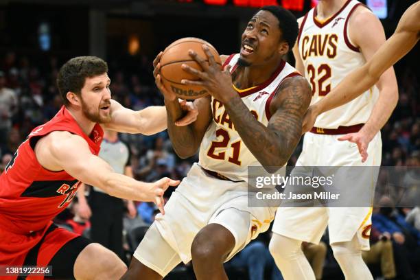 Svi Mykhailiuk of the Toronto Raptors fouls Ed Davis of the Cleveland Cavaliers during the third quarter at Rocket Mortgage Fieldhouse on March 06,...