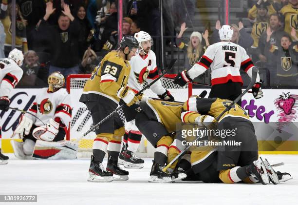 Teammates jump on Jack Eichel of the Vegas Golden Knights after he scored a power-play goal against Anton Forsberg of the Ottawa Senators with 5.9...