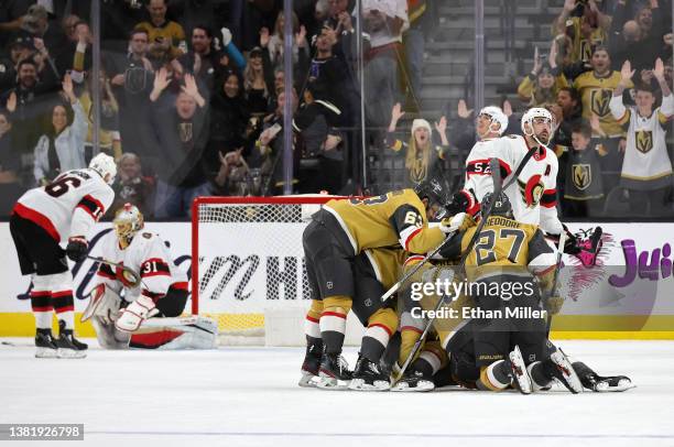 Teammates jump on Jack Eichel of the Vegas Golden Knights after he scored a power-play goal against Anton Forsberg of the Ottawa Senators with 5.9...