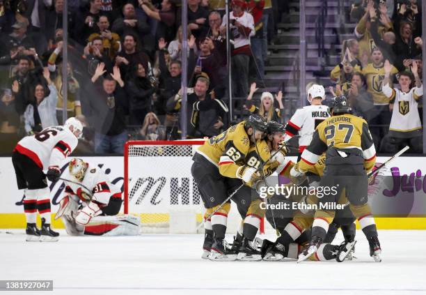 Jack Eichel of the Vegas Golden Knights is tackled by teammates Evgenii Dadonov, Jonathan Marchessault, Max Pacioretty and Shea Theodore after Eichel...