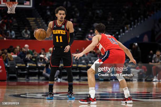 Trae Young of the Atlanta Hawks handles the ball as Raul Neto of the Washington Wizards defends during the first half at Capital One Arena on March...