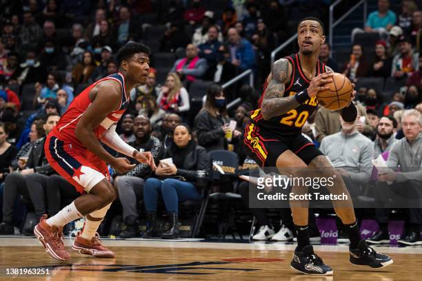 John Collins of the Atlanta Hawks looks to shoot in front of Rui Hachimura of the Washington Wizards during the first half at Capital One Arena on...