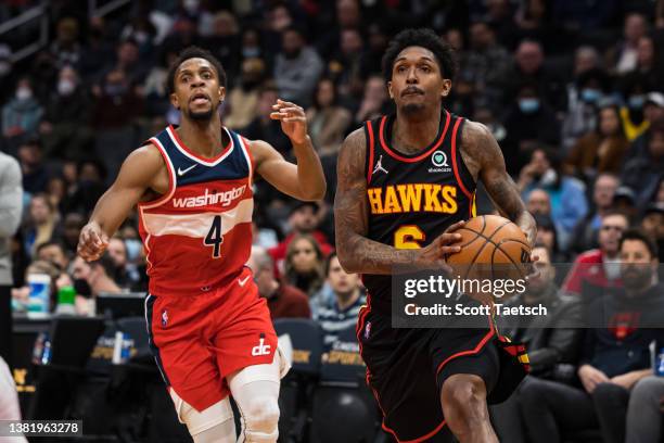 Lou Williams of the Atlanta Hawks drives to the basket against Ish Smith of the Washington Wizards during the first half at Capital One Arena on...