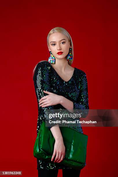 stylish woman in green dress - multi colored purse ストック�フォトと画像