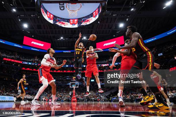Trae Young of the Atlanta Hawks goes to the basket as Kyle Kuzma of the Washington Wizards defends at Capital One Arena on March 4, 2022 in...