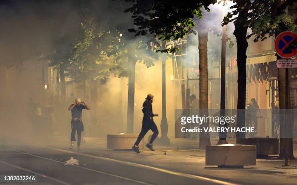 Protestors flee from smoke on a street in Nice, south-eastern France early July 2 during the fifth night of rioting following the shooting of a...