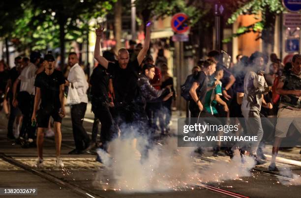 Protestors flee from an exploding firework on a street in Nice, south-eastern France early July 2 during the fifth night of rioting following the...