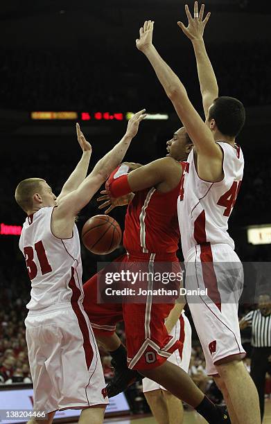 Jared Sullinger of the Ohio State Buckeyes losses control of the ball on a foul as Mike Bruesewitz and Frank Kaminsky of the Wisconsin Badgers defend...