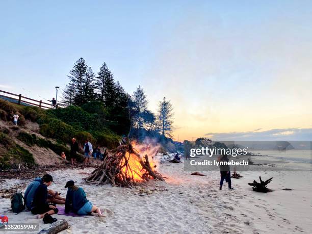 byron bay main beach lagerfeuer bei sonnenuntergang - footprints on beach australia stock-fotos und bilder