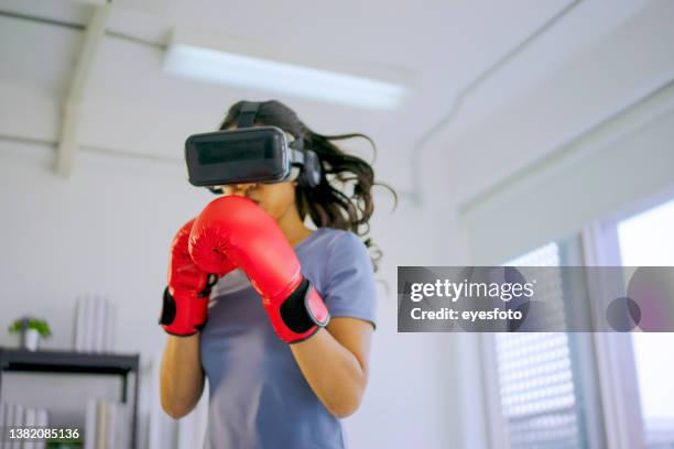 junge frau trainiert mit virtual-reality-brille. - virtuelle realität stock-fotos und bilder