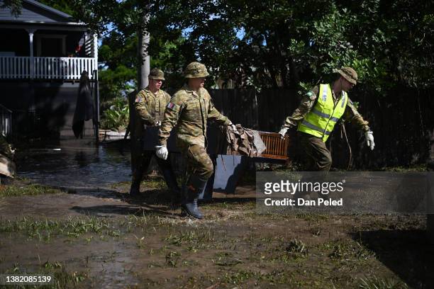 Members of the Australian Defence Forces remove damaged items and debris from a flood-affected house on March 07, 2022 in Woodburn, Australia....