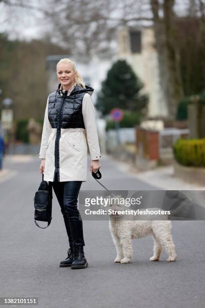 Model Franziska Knuppe wearing a black and cream colored coat by NYLAH by Franzi Knuppe - HSE, black leather pants by NYLAH by Franzi Knuppe - HSE, a...